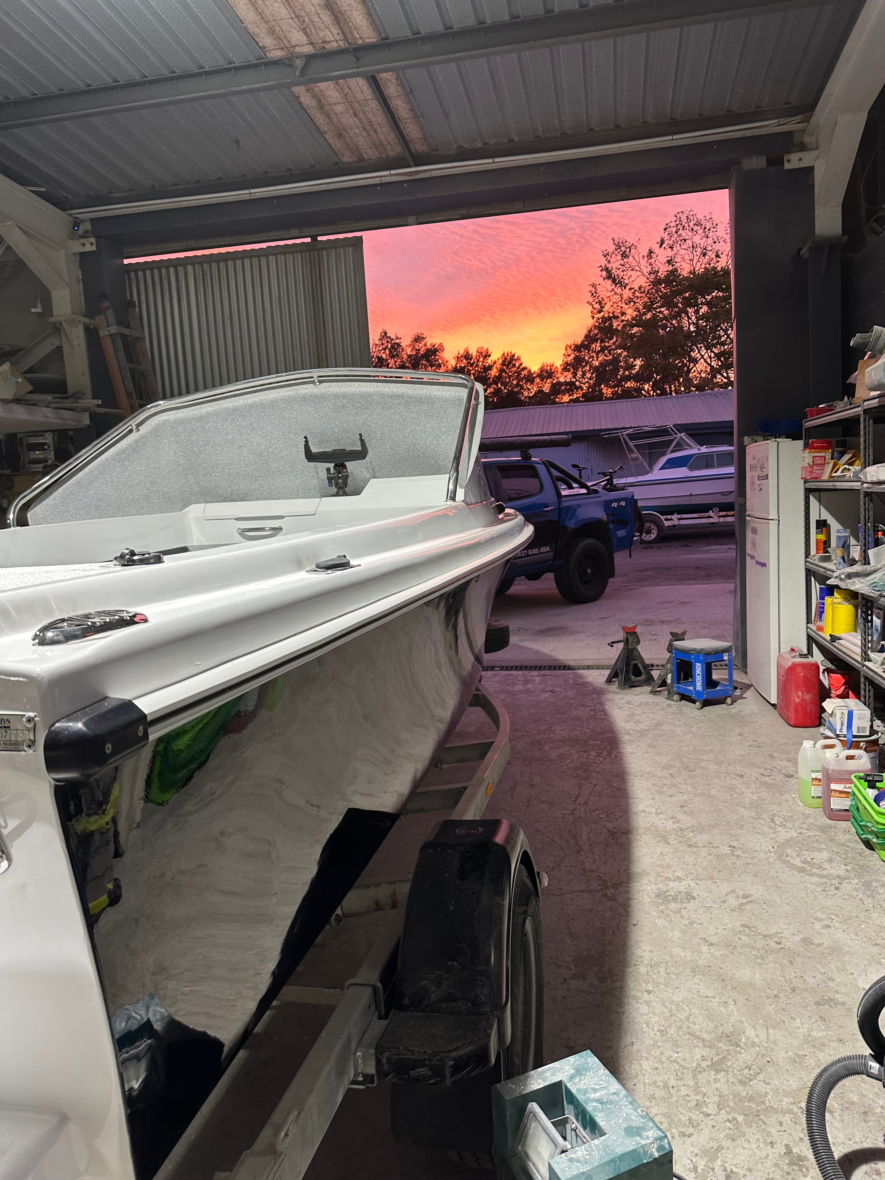 Completed boat in workshop at sunset